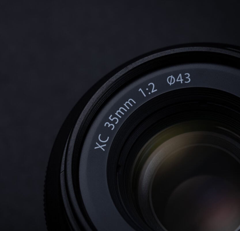 Fujifilm X-M5 Kamera mit XC 35mm F2 Objektiv auf dunklem Hintergrund.